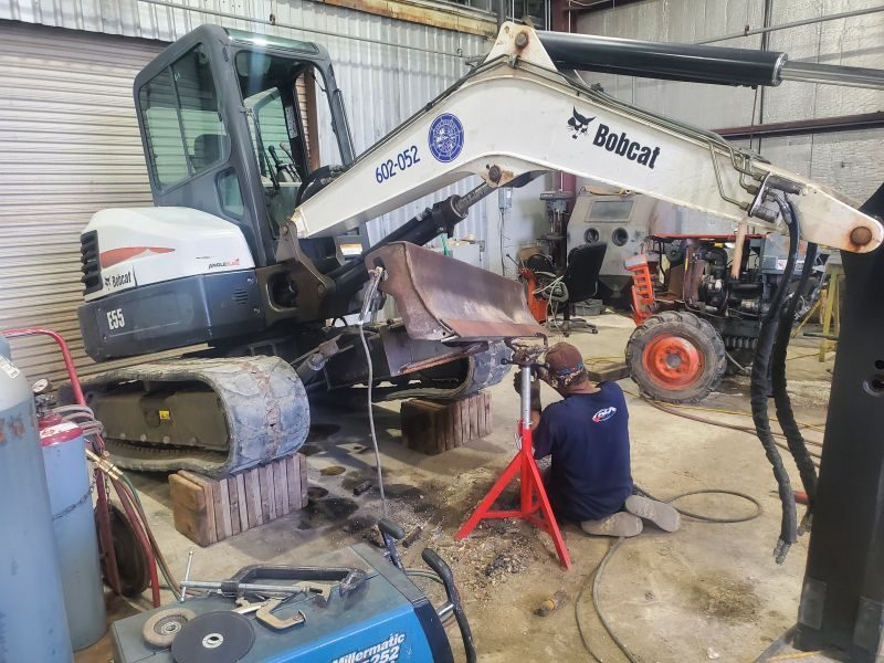 PH technician repairing industrial equipment in the shop
